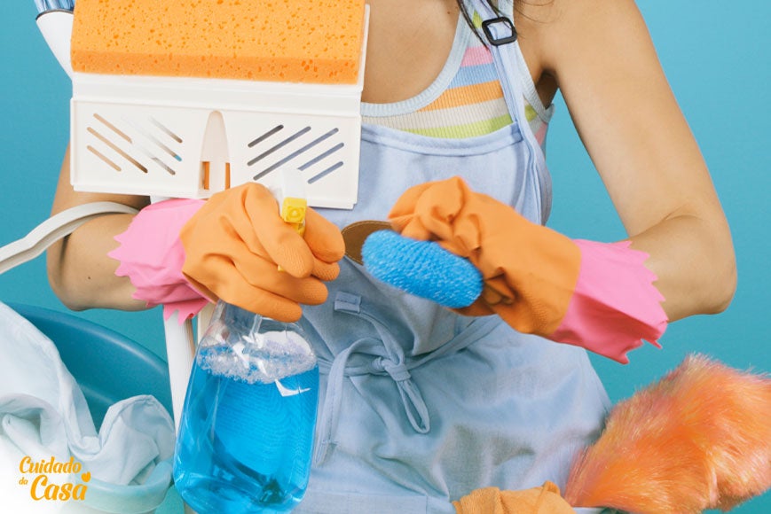 Mulher com produtos de limpeza e esponjas na mão para limpar caixa de gordura