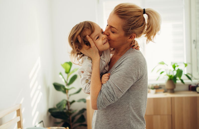 Mamãe com seu pequeno no colo vestindo um pijama para bebê