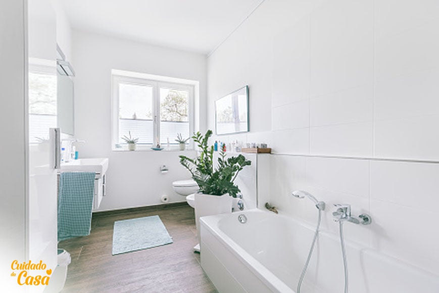 Ambiente após limpeza de banheiro mostrando a banheira, pia, chão e vaso todos muito limpos e branquinhos, banheiro todo arrumado e decorado.
