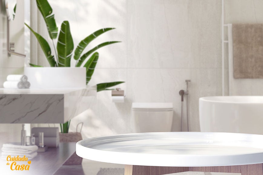 Mulher limpando azulejo de banheiro com esponja e produto de limpeza para remover sujeira e manchas.