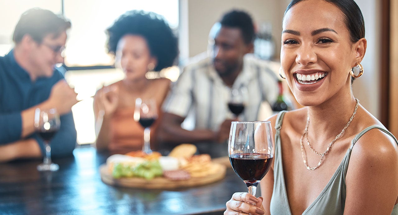 Grupo de amigos sentados à mesa saboreando uma deliciosa tábua de frios