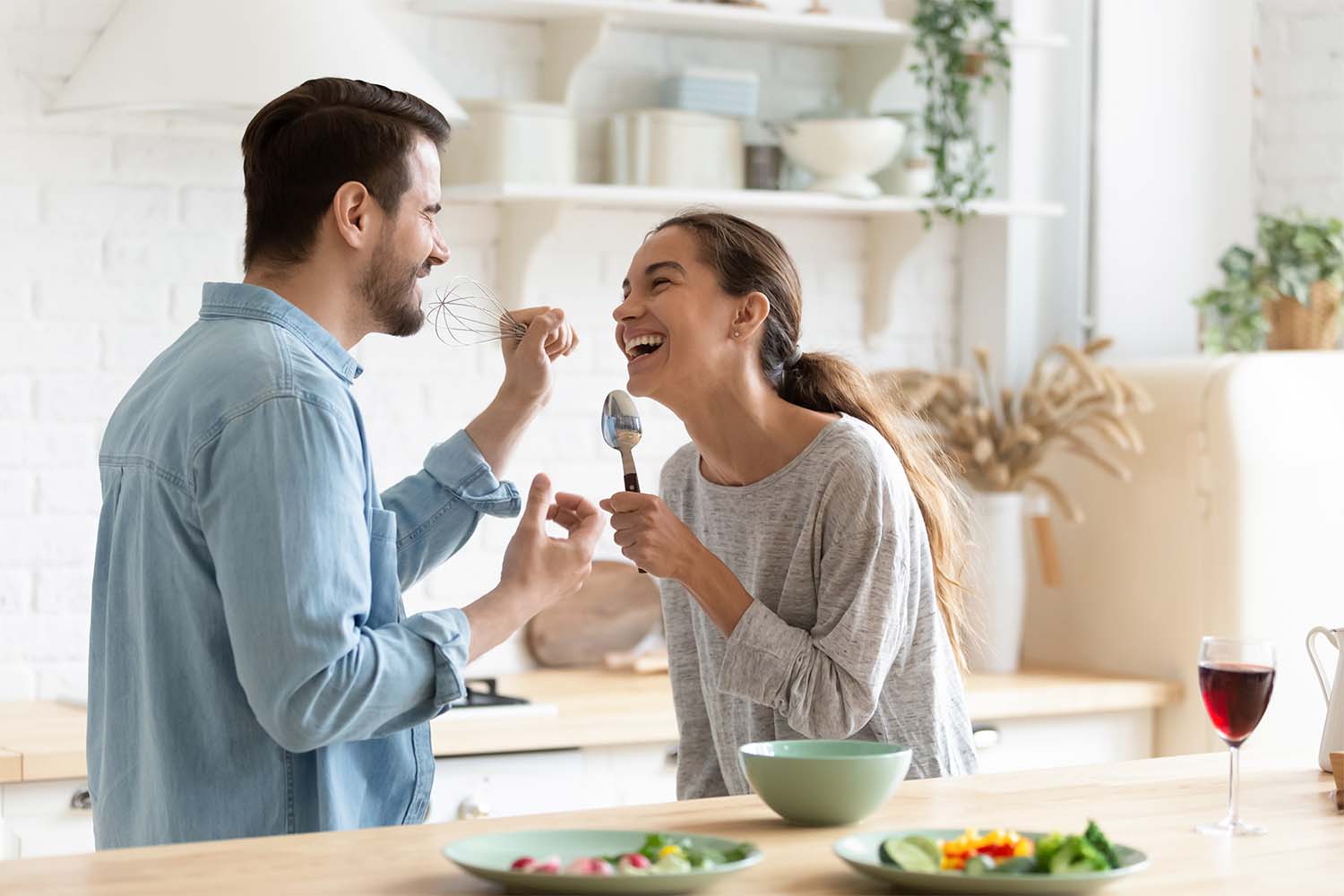 Casal preparando um patê especial para acompanhar a tábua de frios